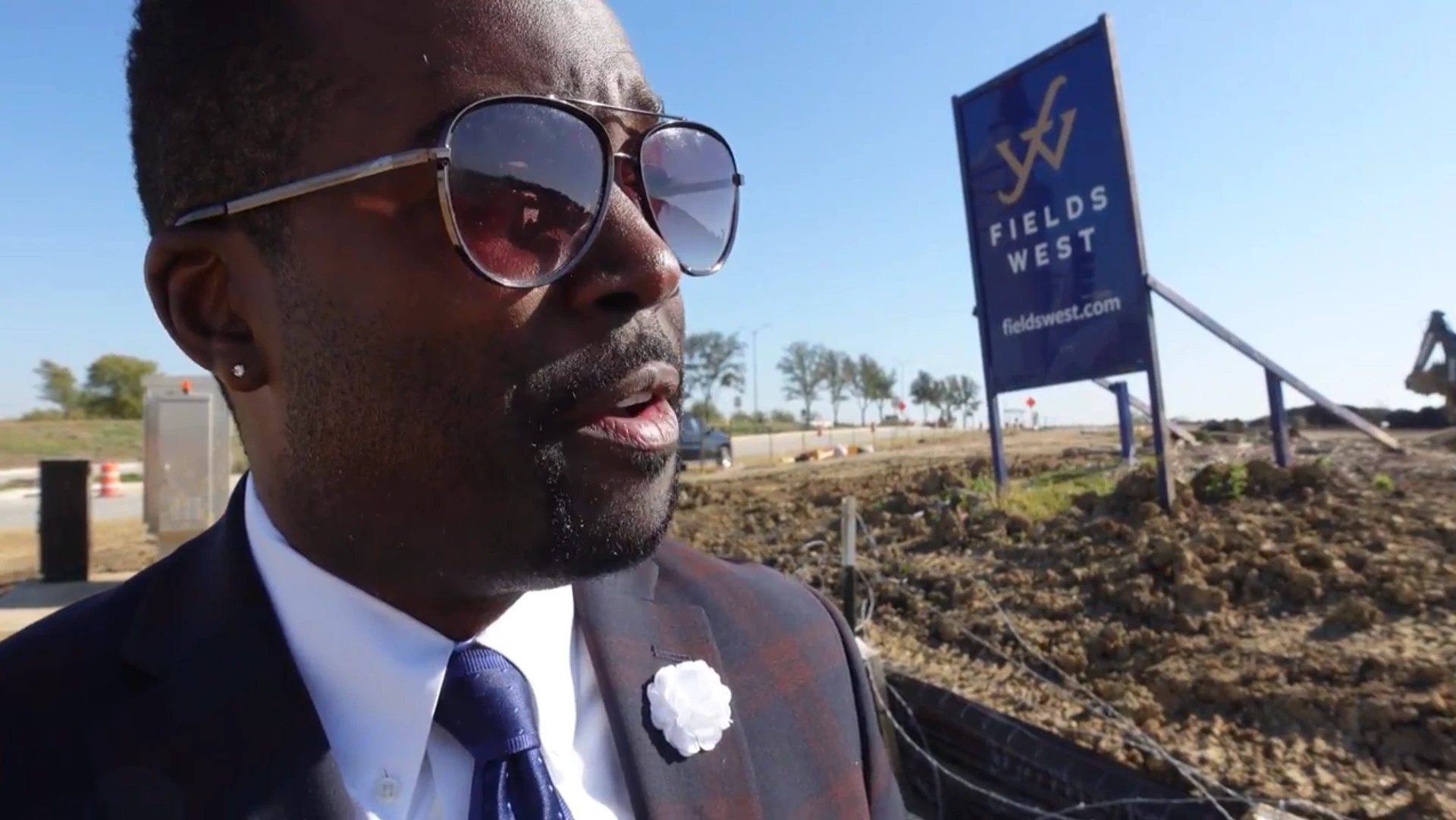 Tommy Wooten beside the Fields West sign as vertical construction begins in Frisco, Texas