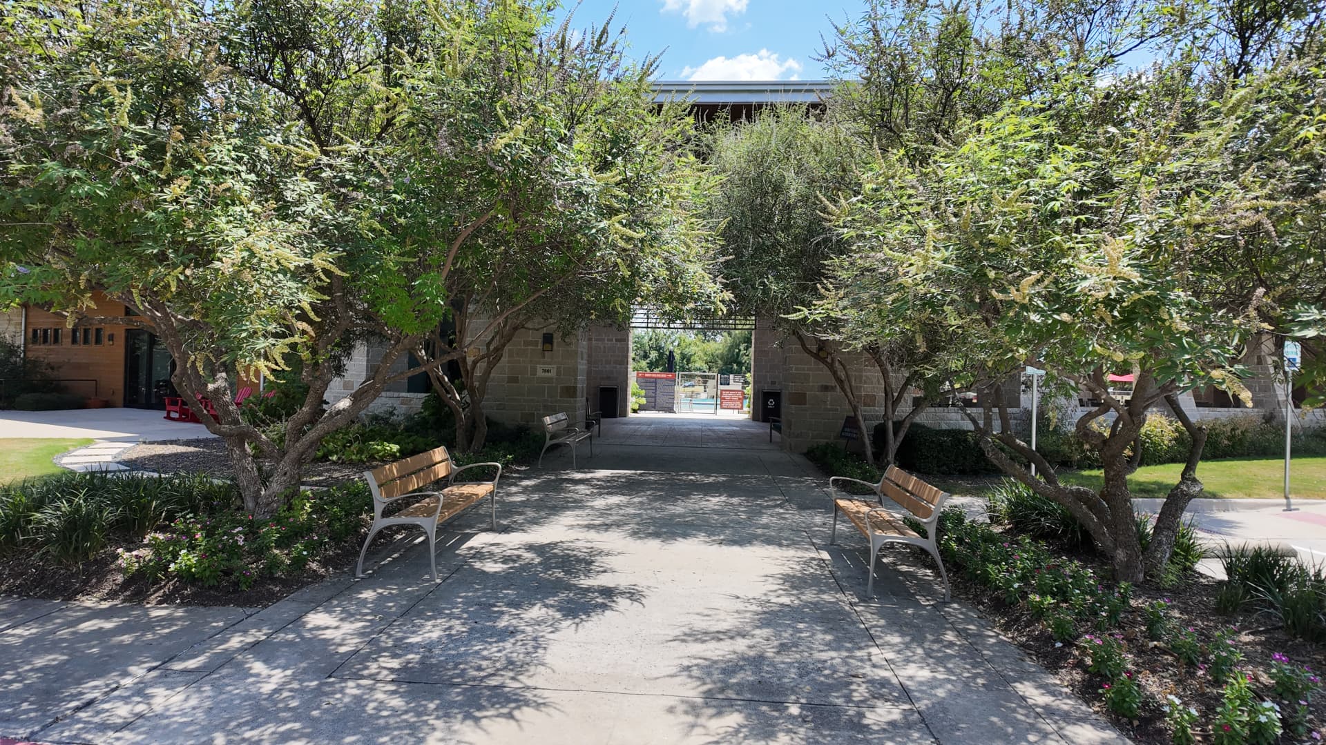 Shaded tree-lined walkway leading to the Trinity Falls amenity lodge and pool gate
