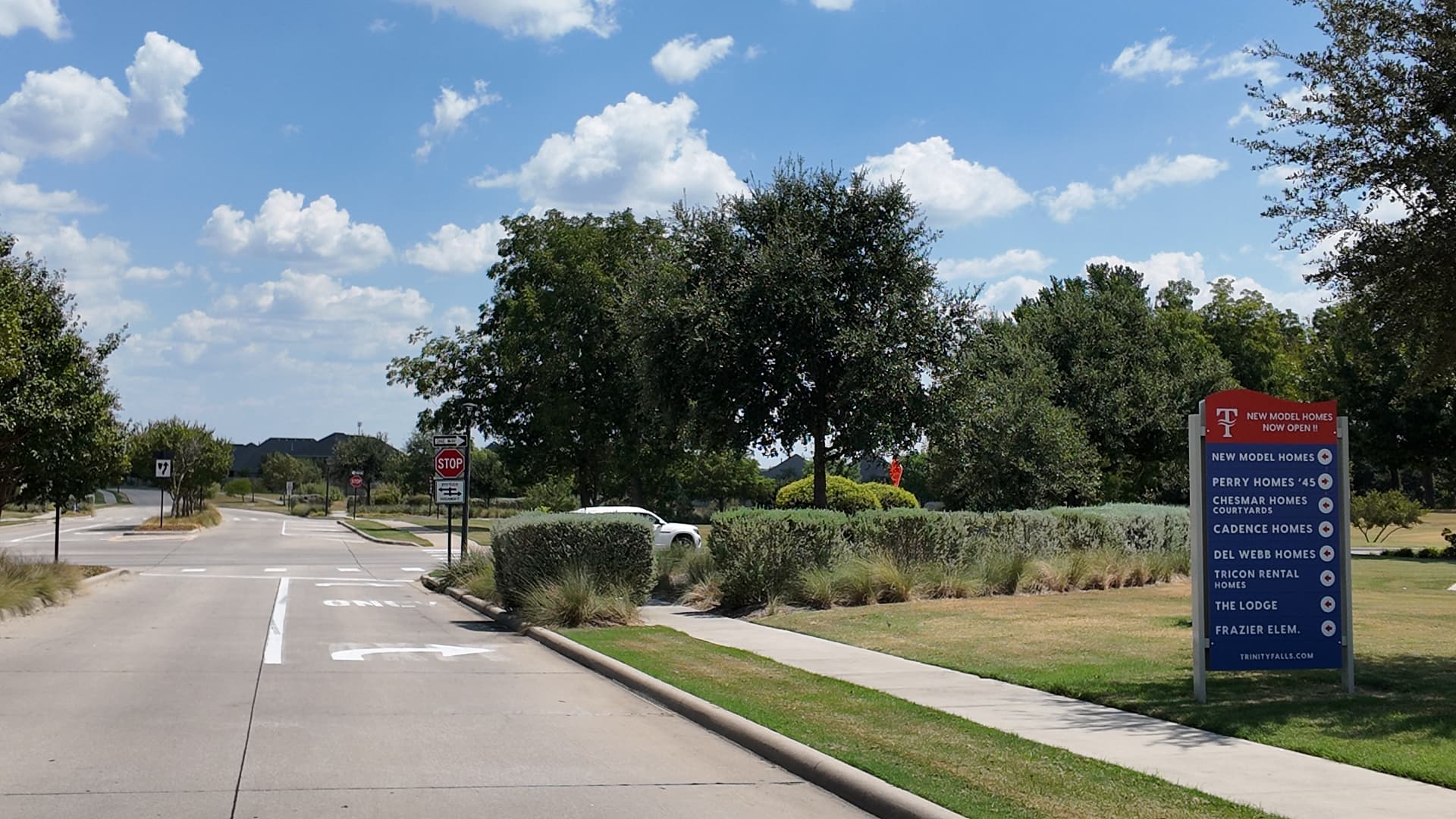 Roadside Trinity Falls builder sign near a residential intersection in McKinney