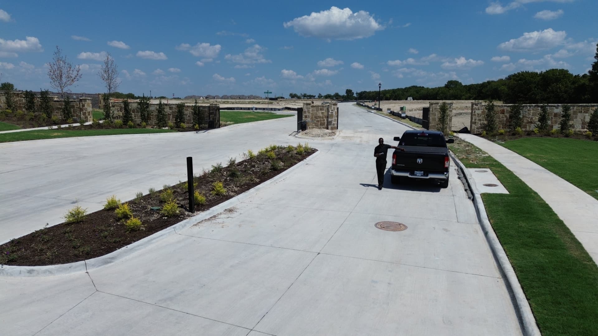 Gated entry street at Aster Park with stone monuments and new homesites